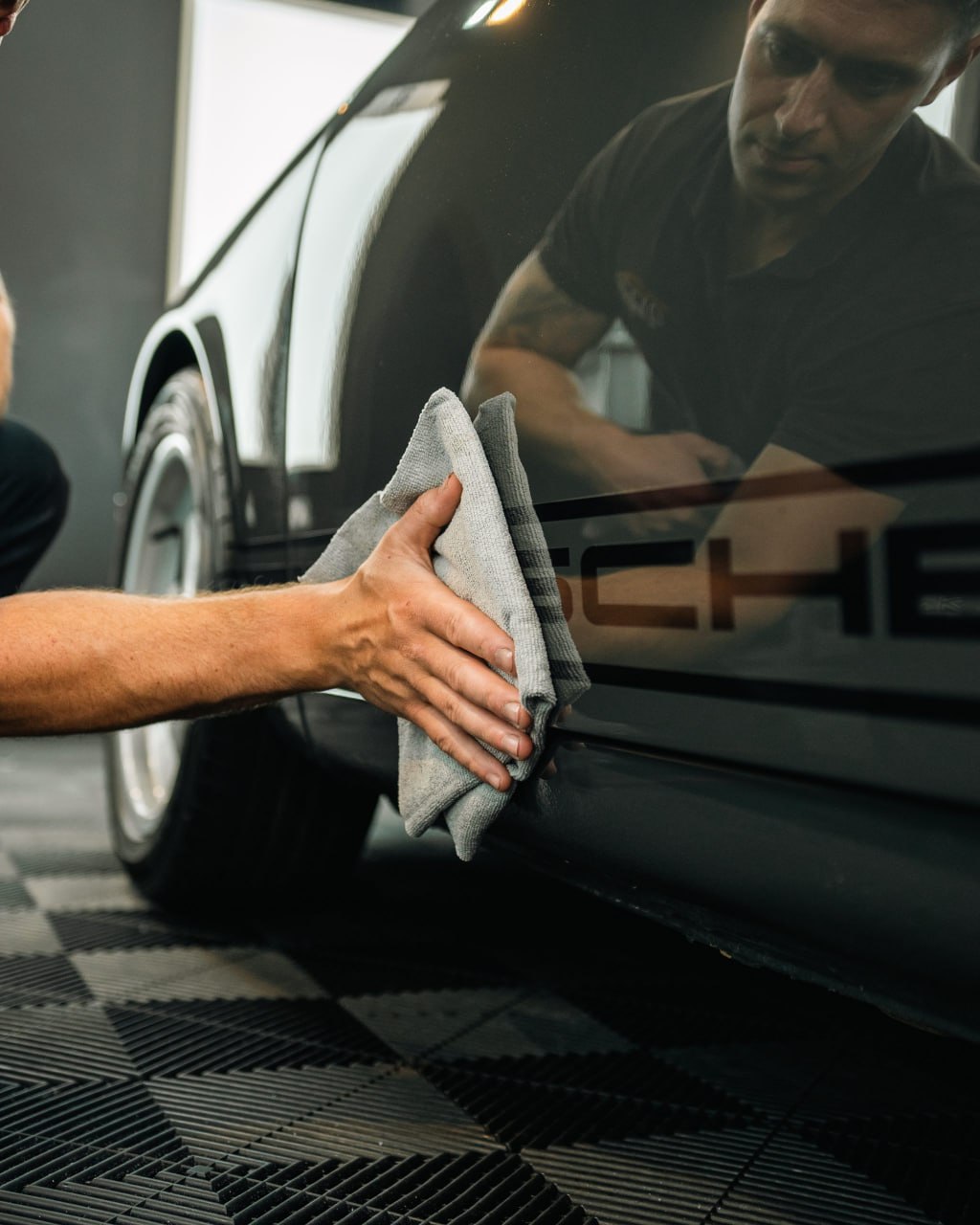 Hand detailing a black Porsche — True Time Auto Detailing
